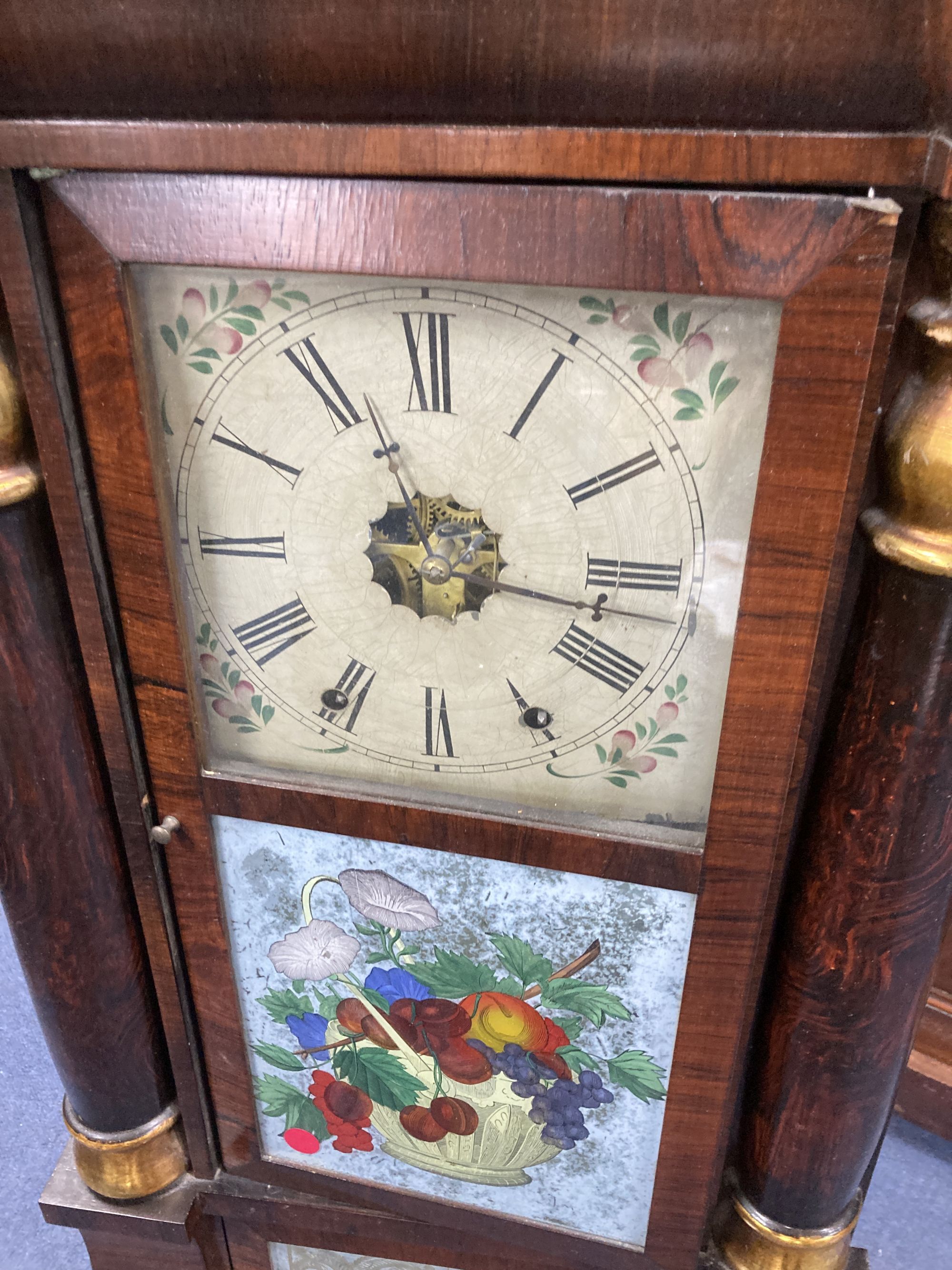 A 19th century American simulated rosewood wall clock, height 84cm, a 19th century inlaid wall clock and a mahogany pedestal cupboard